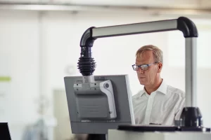 operatör står i en ljus lokal och programmerar en kantvik i styrsystemet prolink