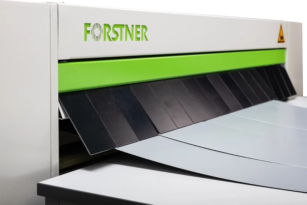 metal is cut by a guillotine shear behind a saftey curtain on nuslit cut to length nuslit on white background