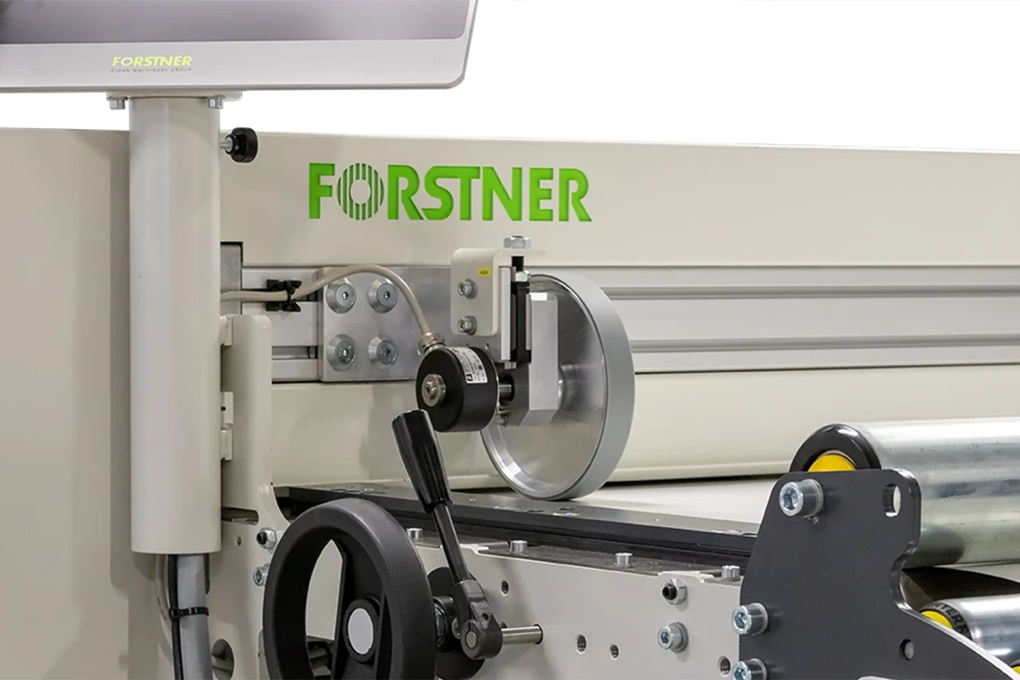 mäthjul som mäter inmatad längd på plåt i en klippsträcka mot vit bakgrund